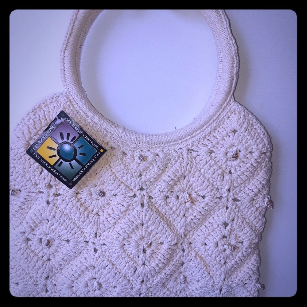Crocheted handbag with mini seashell accents.